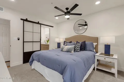 a bedroom with a large bed and a chandelier