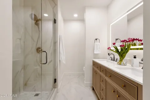 a bathroom with a shower sink vanity and mirror