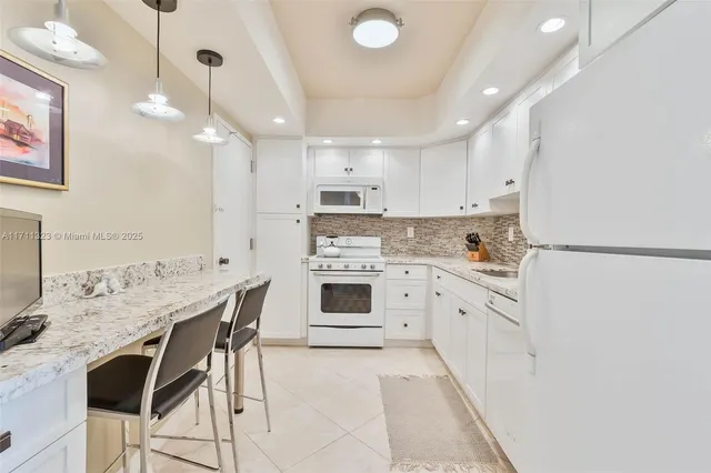 a kitchen with stainless steel appliances kitchen island granite countertop a stove a sink a dining table and chairs