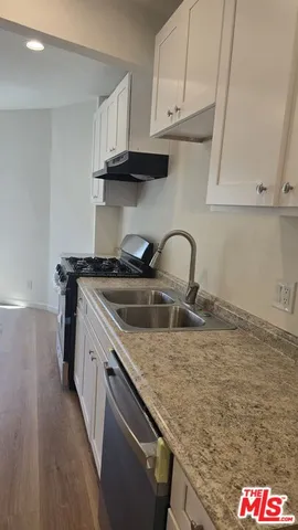 a kitchen with granite countertop a sink and a stove