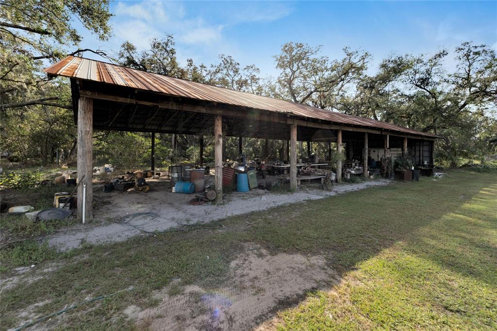5030 Sydney Road Plant City, FL 33566 - Photo 8 of 23 a view of a patio with table and chairs under an umbrella with large trees