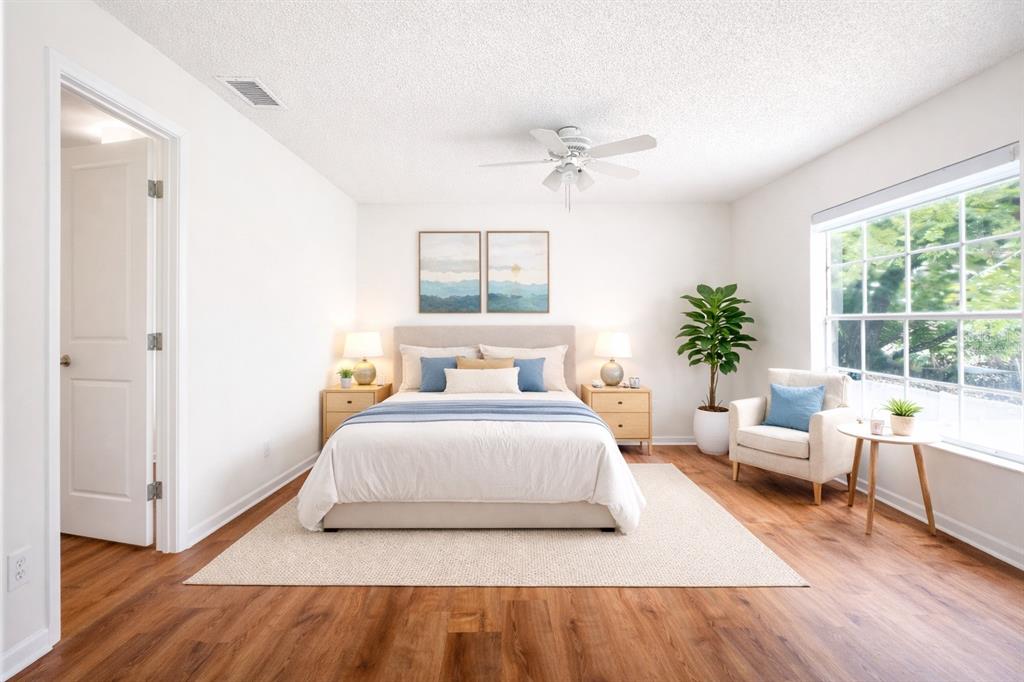 11008 Yorkshire Ridge Court Orlando, FL 32837 - Photo 15 of 24 a spacious bedroom with a bed and wooden floor