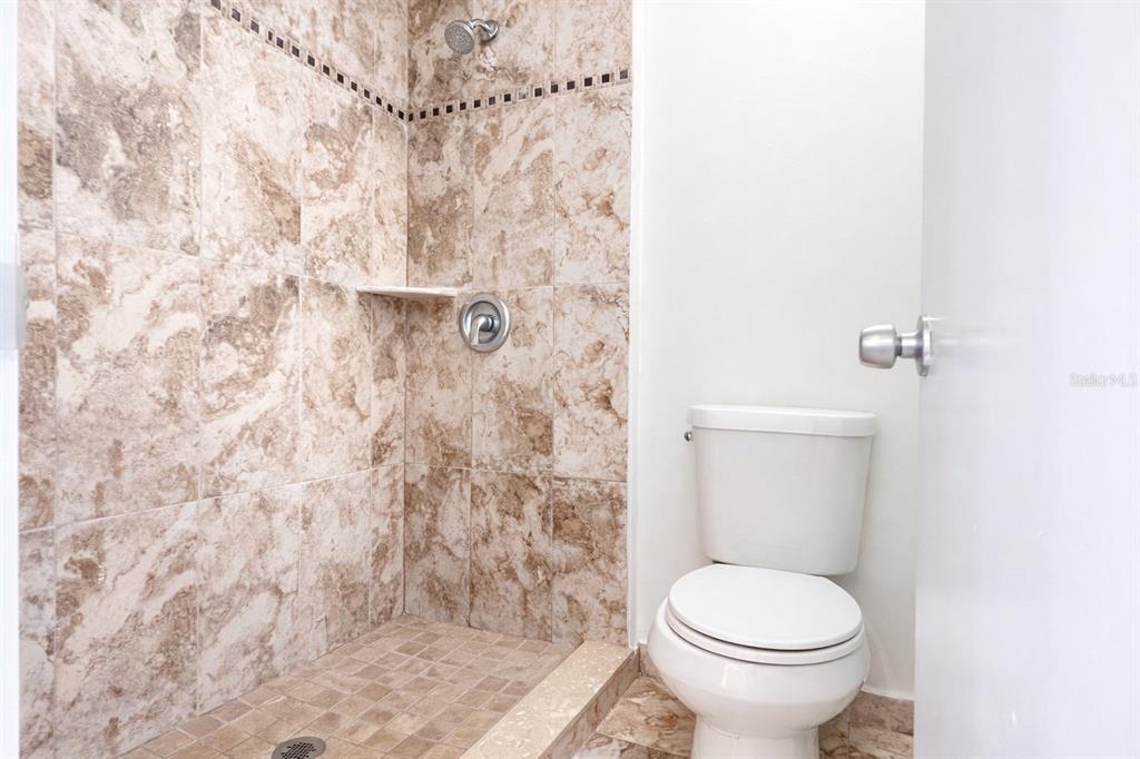 11008 Yorkshire Ridge Court Orlando, FL 32837 - Photo 16 of 24 a white toilet sitting next to a shower