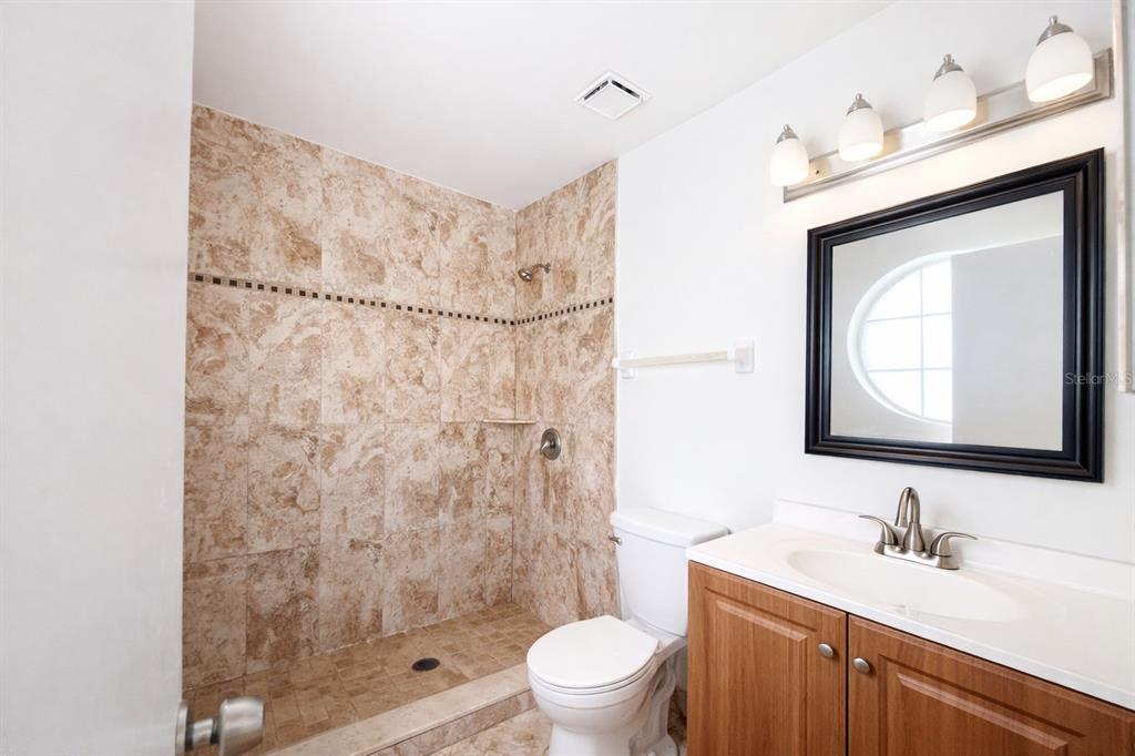 11008 Yorkshire Ridge Court Orlando, FL 32837 - Photo 19 of 24 a bathroom with a granite countertop sink a toilet and a mirror
