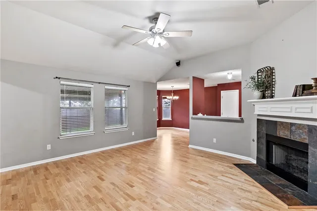 a view of an empty room with window and fireplace