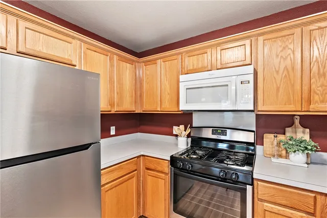 a kitchen with stainless steel appliances granite countertop cabinets and a window