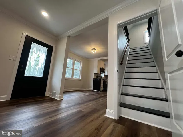 a view of a livingroom with wooden floor and stairs