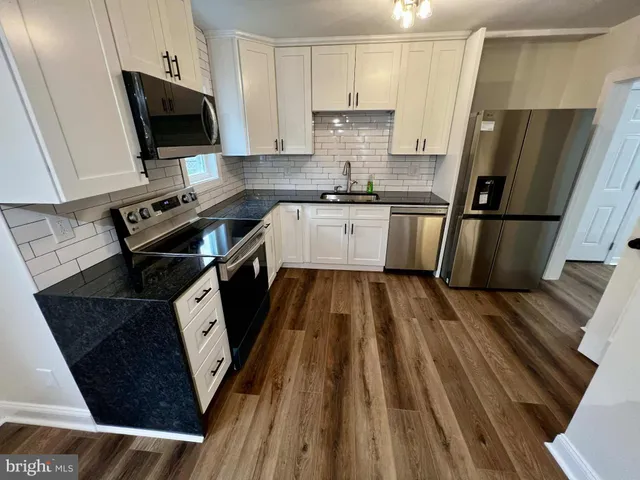 a kitchen with a sink a refrigerator a stove a microwave and cabinets