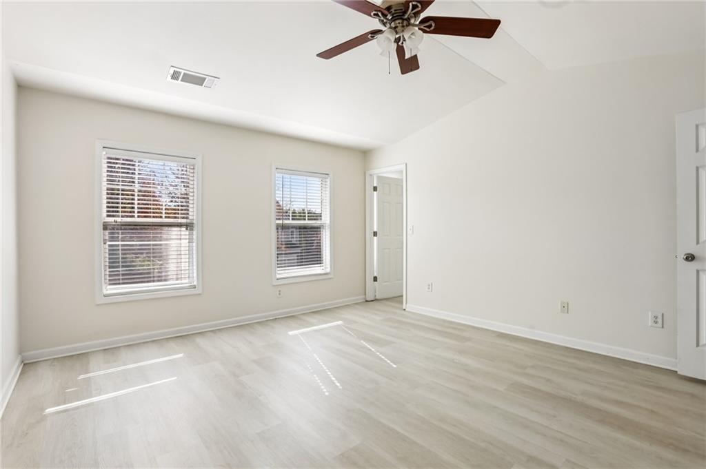 5940 Bentley Way Cumming, GA 30040 - Photo 24 of 39 an empty room with window and a ceiling fan