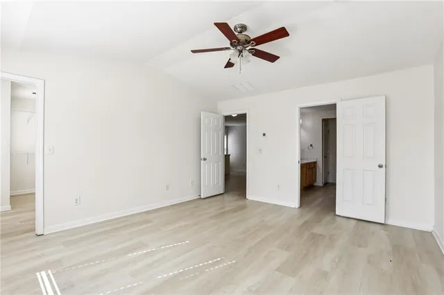 an empty room with closet and ceiling fan