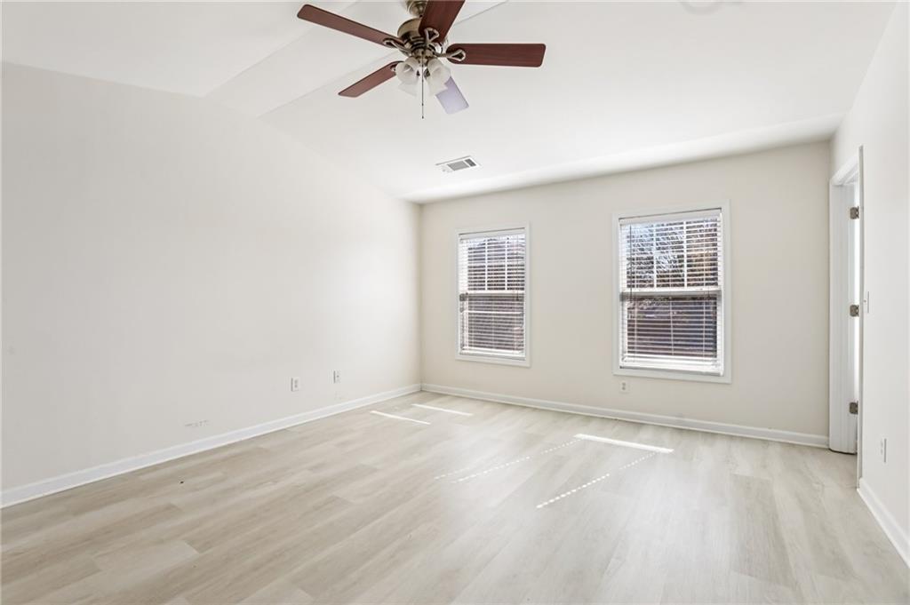 5940 Bentley Way Cumming, GA 30040 - Photo 27 of 39 an empty room with wooden floor fan and windows