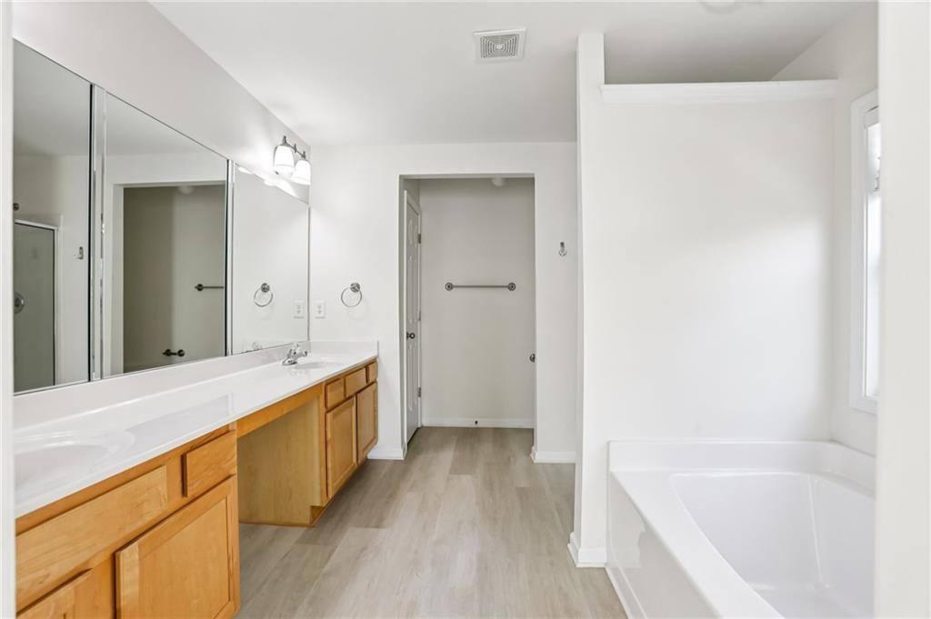 5940 Bentley Way Cumming, GA 30040 - Photo 29 of 39 a spacious bathroom with a tub sink and mirror