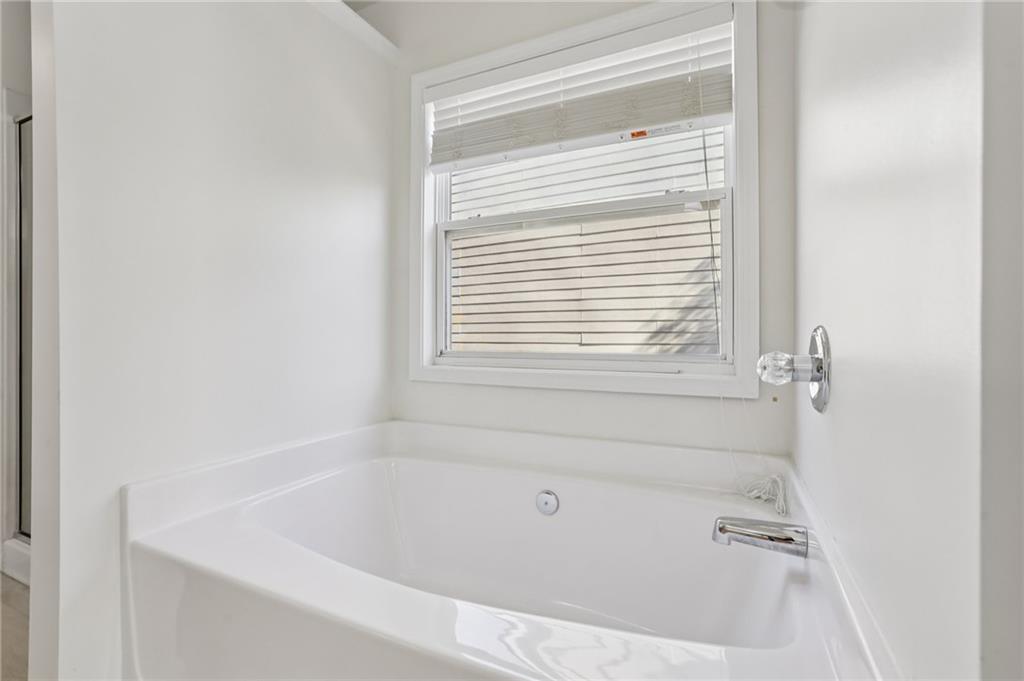 5940 Bentley Way Cumming, GA 30040 - Photo 32 of 39 a white bath tub sitting next to a window
