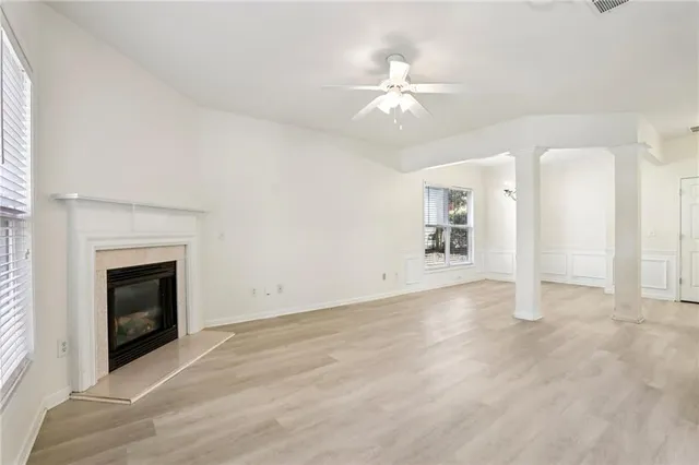 an empty room with fan and fireplace