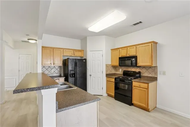 a kitchen with stainless steel appliances granite countertop a stove a sink and a refrigerator