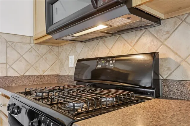 a stove top oven sitting inside of a kitchen