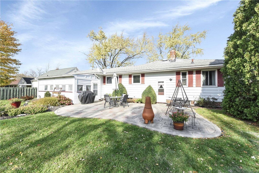 Back of property with a patio area and a lawn