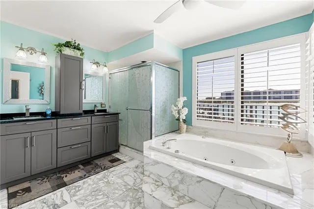 a bathroom with a granite countertop tub sink and mirror