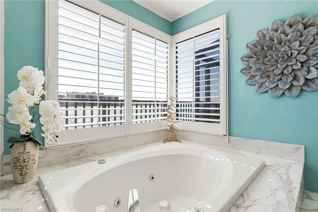 305 La Peninsula Boulevard, Unit 305 Naples, FL 34113 - Photo 14 of 23 a bathroom with a bathtub and shower