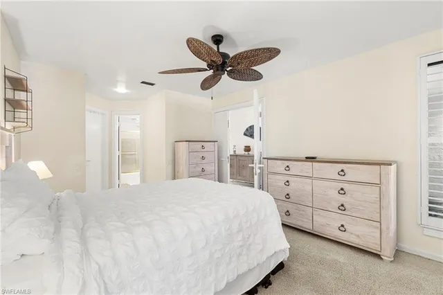 a spacious bedroom with a bed and a ceiling fan