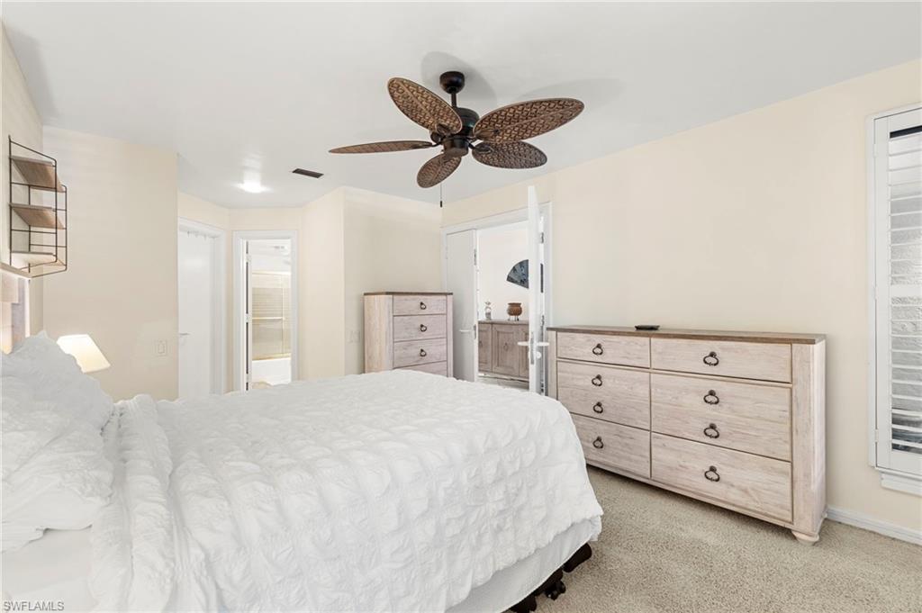 305 La Peninsula Boulevard, Unit 305 Naples, FL 34113 - Photo 17 of 23 a spacious bedroom with a bed and a ceiling fan