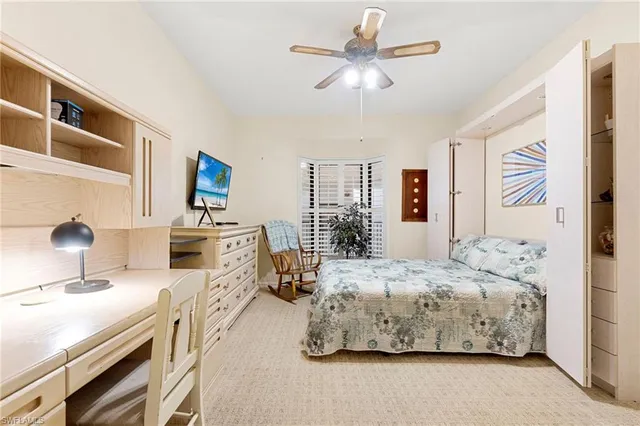 a bedroom with a bed a large window and wall painting