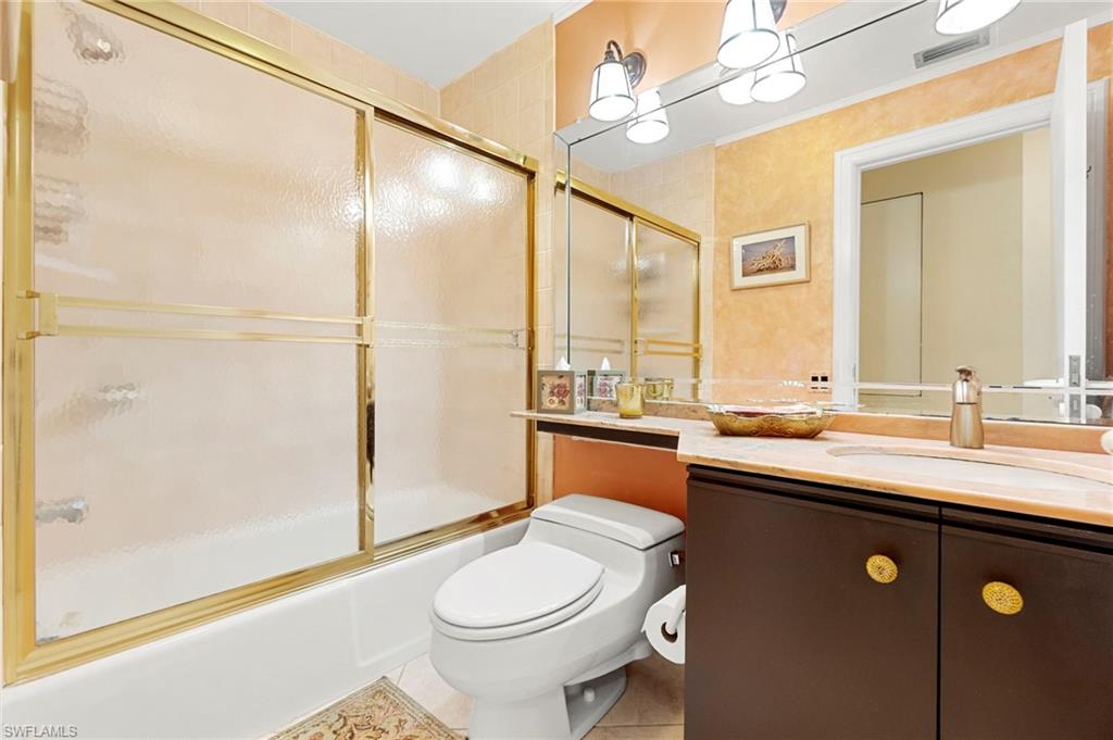 305 La Peninsula Boulevard, Unit 305 Naples, FL 34113 - Photo 20 of 23 a bathroom with a sink a toilet and shower