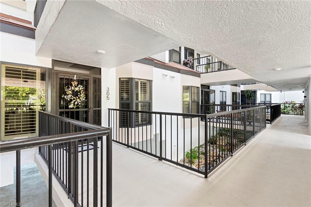 305 La Peninsula Boulevard, Unit 305 Naples, FL 34113 - Photo 3 of 23 a view of a living room and balcony