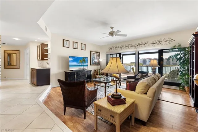 a living room with furniture a flat screen tv and a large window