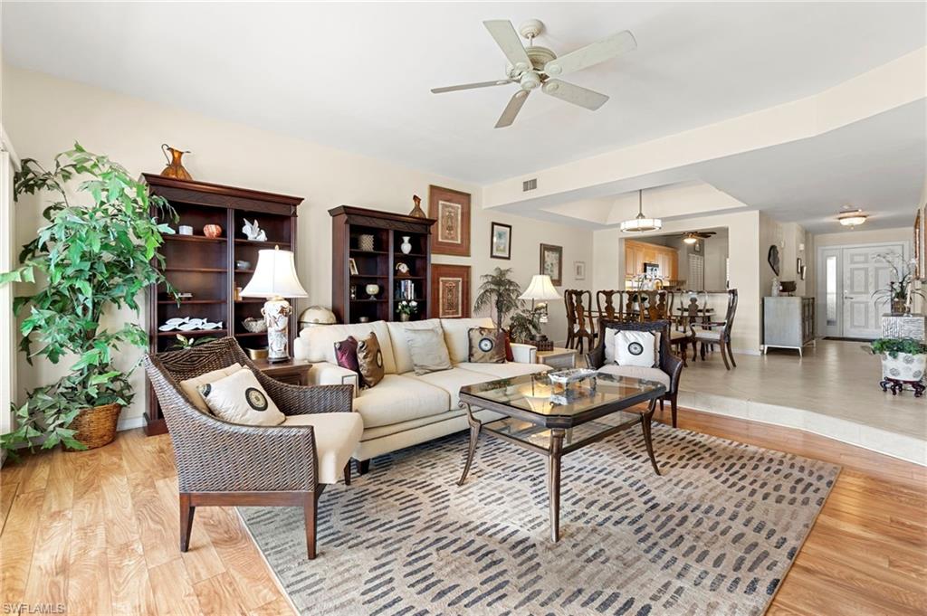 305 La Peninsula Boulevard, Unit 305 Naples, FL 34113 - Photo 8 of 23 a living room with furniture and wooden floor