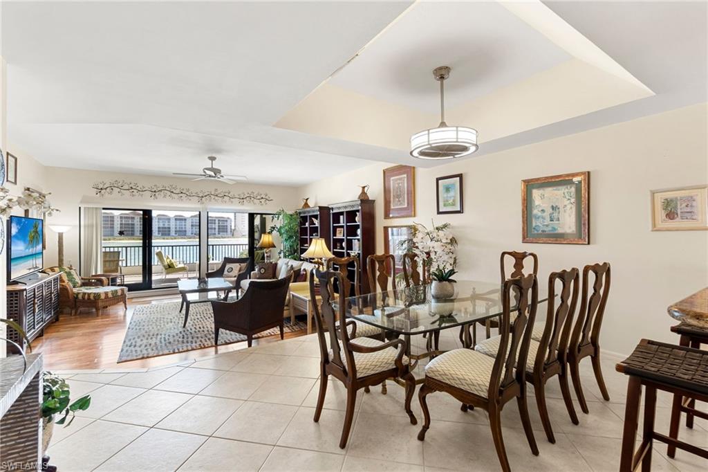305 La Peninsula Boulevard, Unit 305 Naples, FL 34113 - Photo 9 of 23 a view of a livingroom and a dining room with furniture window and wooden floor