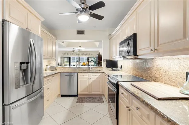 a kitchen with a sink stainless steel appliances a refrigerator and cabinets