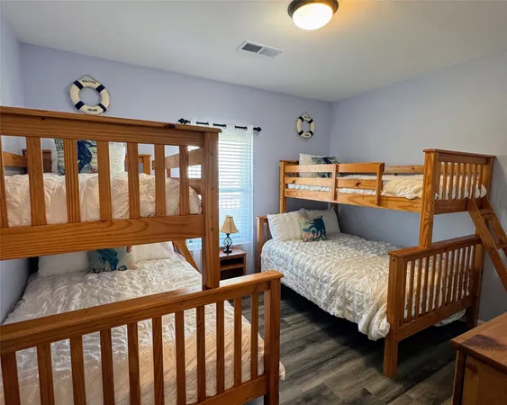 a bedroom with a bed a flat screen tv and dresser