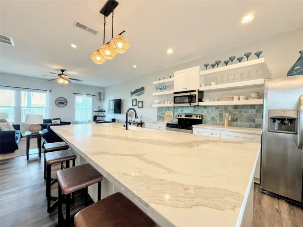 a kitchen with stainless steel appliances granite countertop a stove and white cabinets