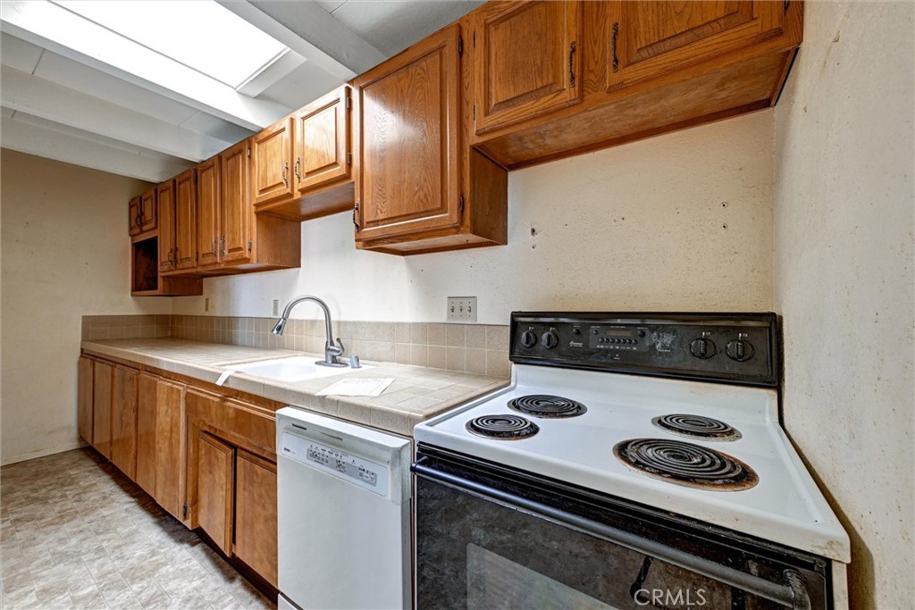 604 Gibbel Road Hemet, CA 92543 - Photo 14 of 29 a kitchen with stainless steel appliances a stove a sink dishwasher and cabinets with wooden floor