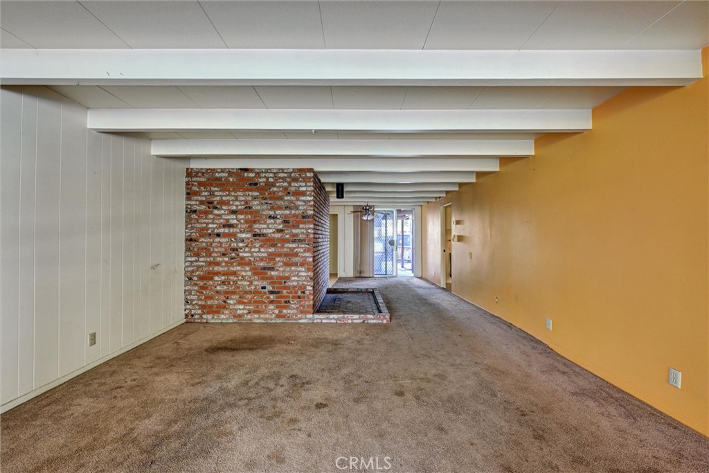 604 Gibbel Road Hemet, CA 92543 - Photo 7 of 29 a view of an empty room with a fireplace and a window