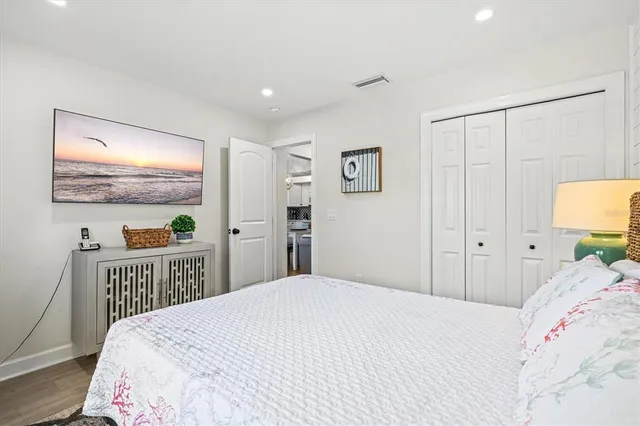 a kitchen with stainless steel appliances granite countertop a stove top oven a sink dishwasher a dining table and chairs with wooden floor