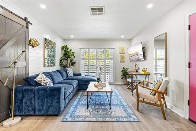 a living room with furniture kitchen view and a potted plant
