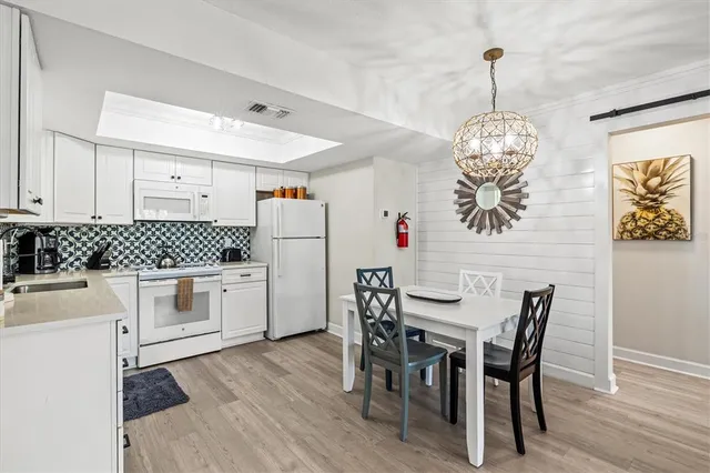 a kitchen with white cabinets and window