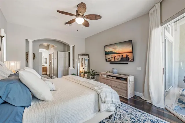 a bedroom with a bed a mirror on the wall and dresser