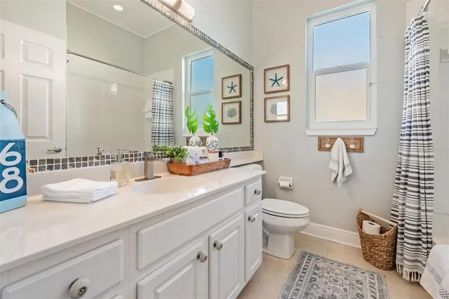 a bathroom with a granite countertop toilet sink and a mirror