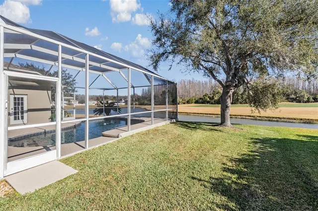 a view of an house with backyard and tree