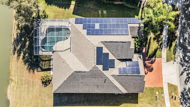 an aerial view of residential houses with outdoor space and lake view
