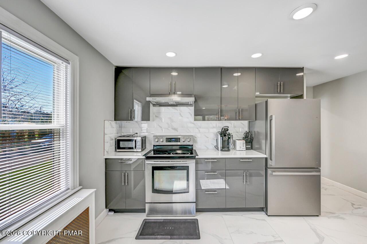 112 Trach Road Kunkletown, PA 18058 - Photo 24 of 48 a kitchen with stainless steel appliances granite countertop white cabinets a refrigerator a sink a stove and a refrigerator