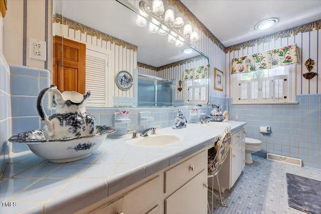 a bathroom with a sink a toilet and a mirror