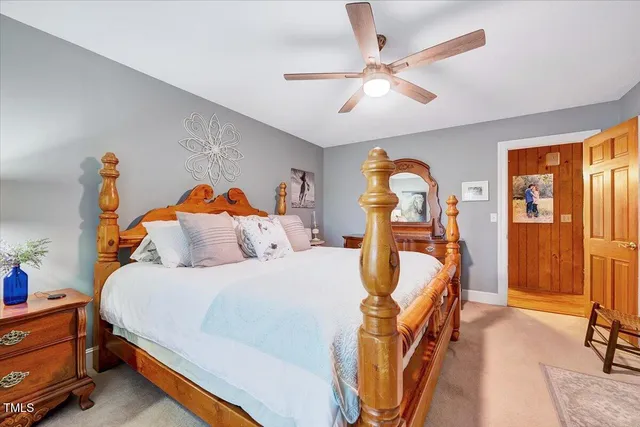 a bedroom with a bed and a large mirror on the dresser