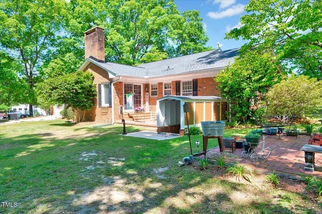 a view of a house with backyard and sitting area