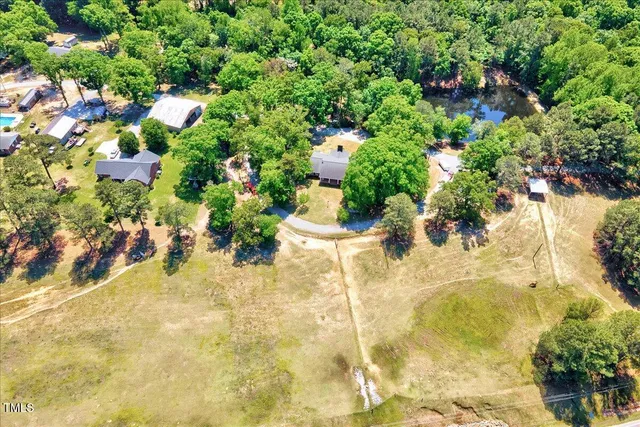 an aerial view of residential houses with outdoor space and trees