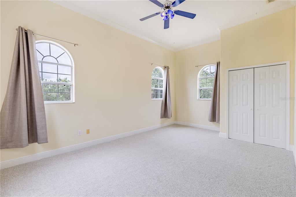 2718 Knightsbridge Road Clermont, FL 34711 - Photo 12 of 72 an empty room with windows and chandelier fan