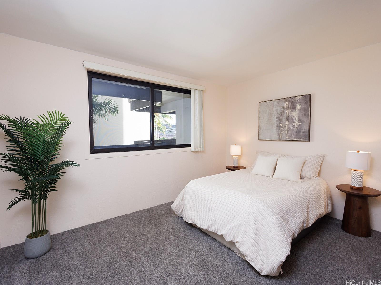 500 Lunalilo Home Road, Unit 13B Honolulu, HI 96825 - Photo 11 of 17 a bedroom with a bed lamp and a potted plant